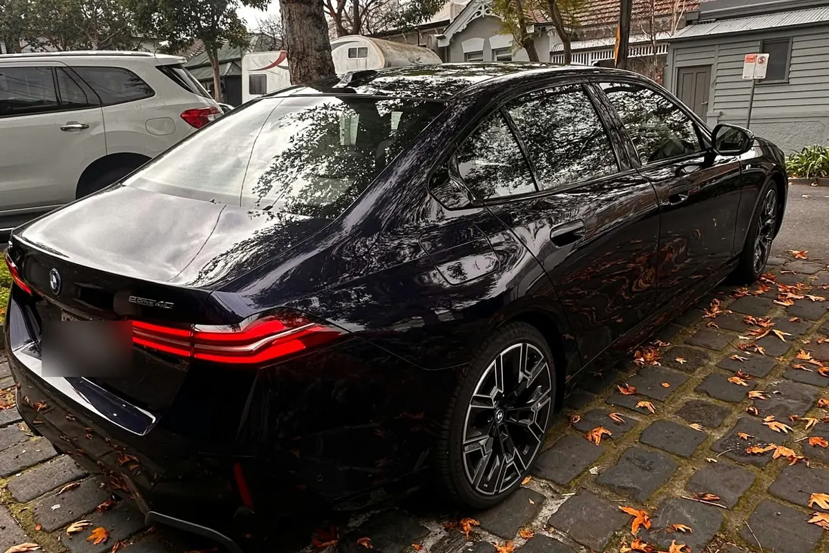 Rear view of a black BMW 5 Series chauffeur car on a Melbourne street