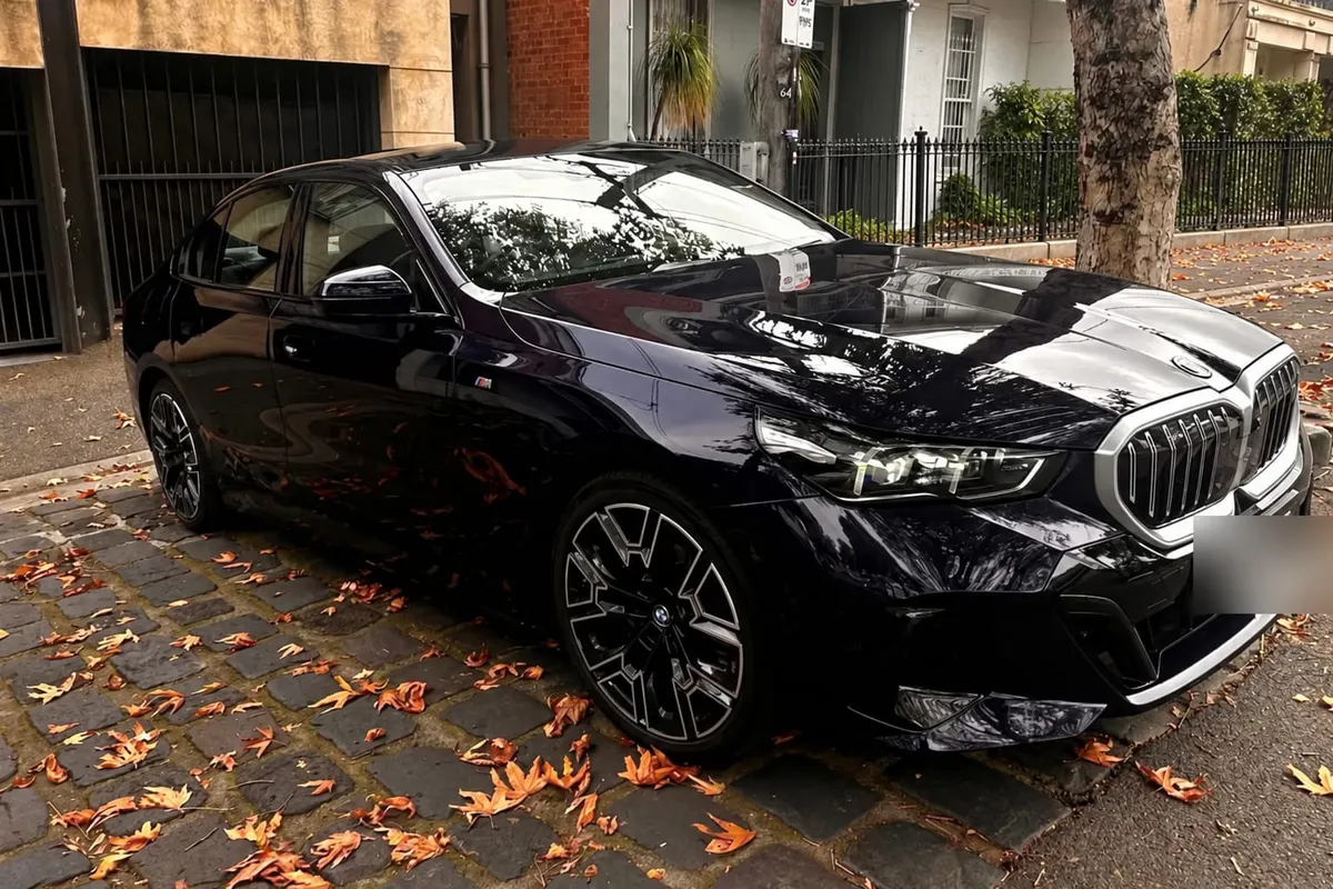 Black BMW i5 chauffeur car parked on a cobbled Melbourne back street