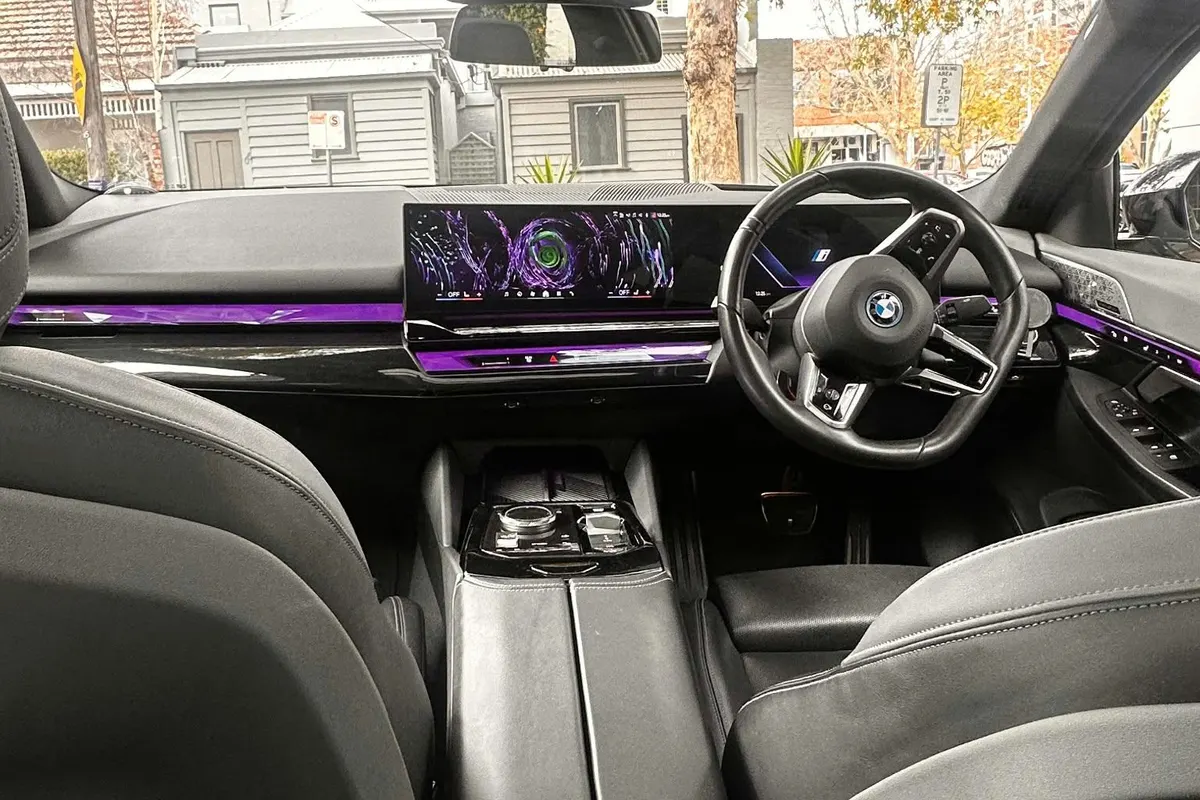 Front cabin of a Business Class car showing the curved display and ambient lighting