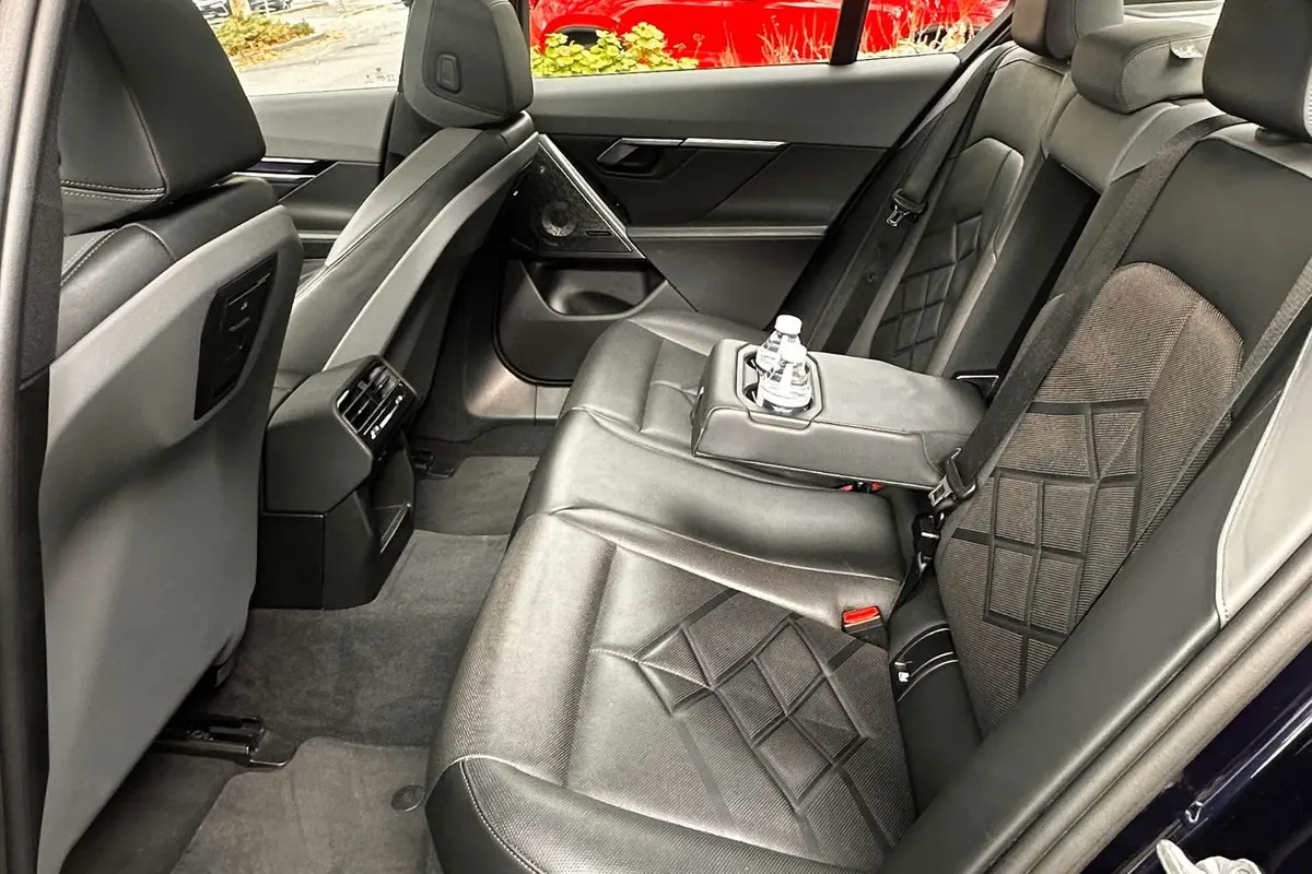 Rear seat of a Business Class car with bottled water in the centre armrest